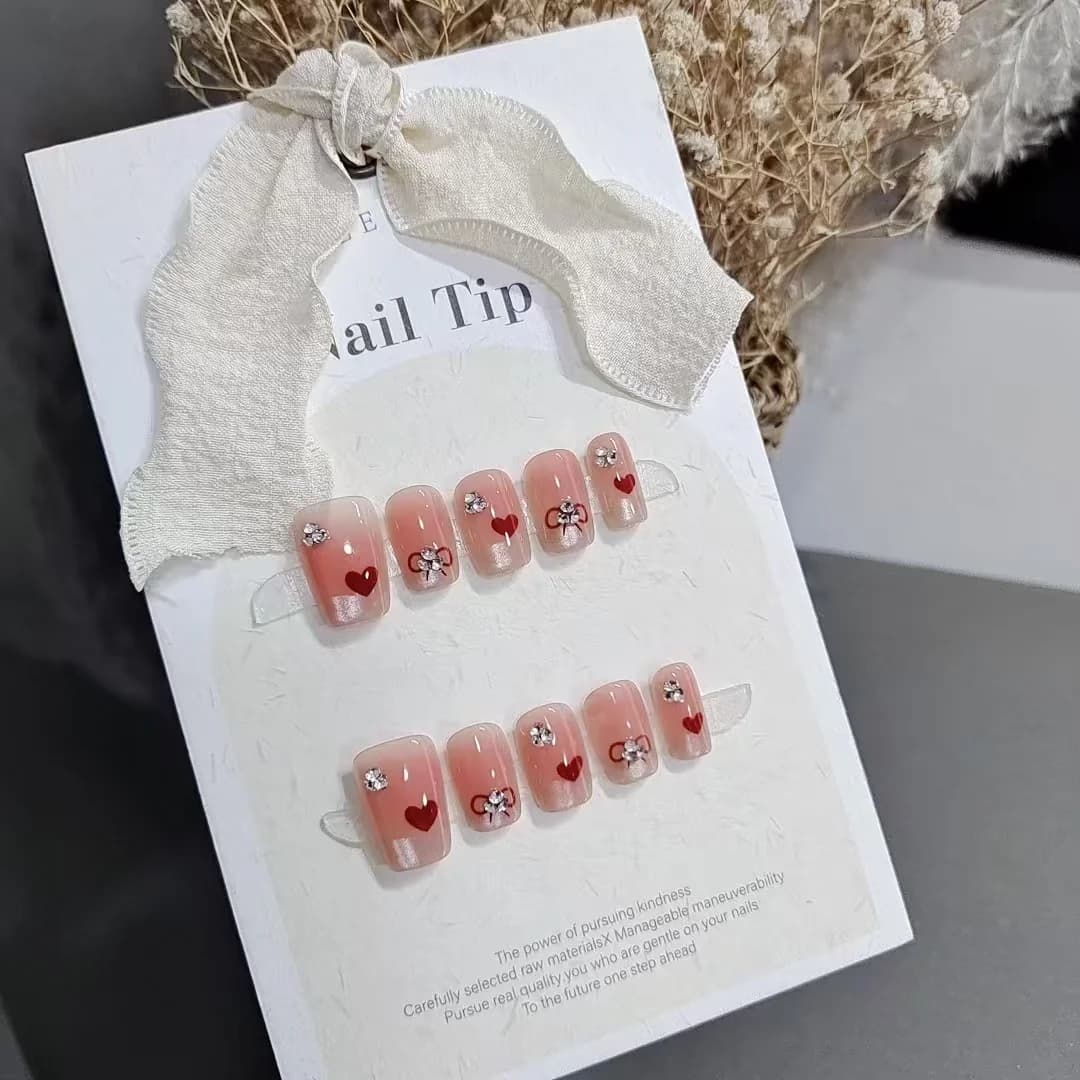 Ongles à poser courts carrés French Sweetheart avec cœurs et nœuds