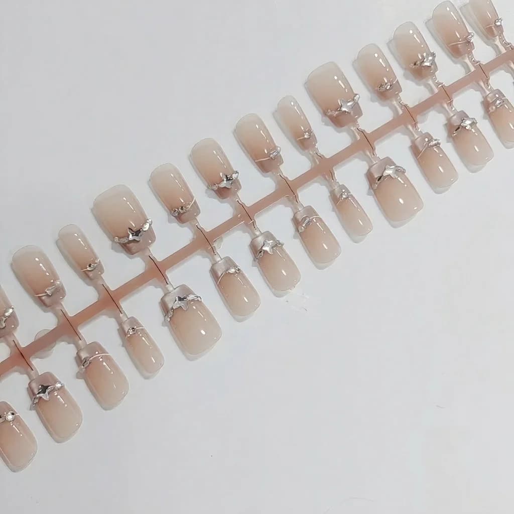 Faux ongles French avec strass papillon et effet œil de chat