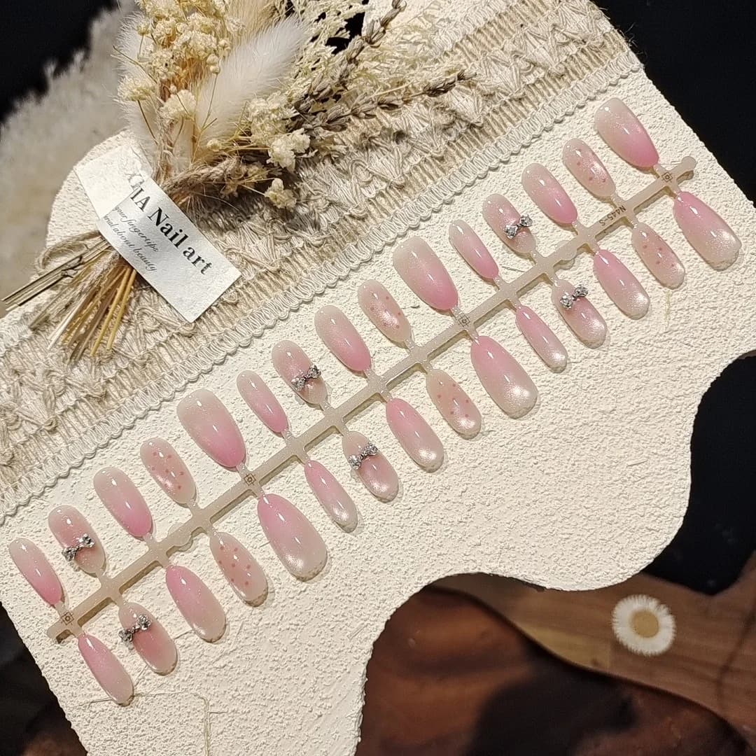Faux ongles œil de chat rose avec nœud et perles de verre