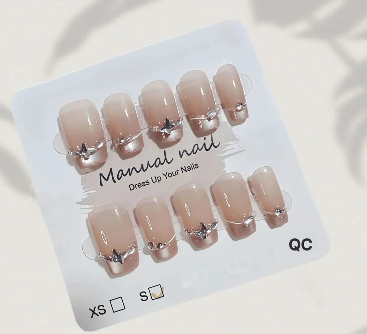 Faux ongles French avec strass papillon et effet œil de chat