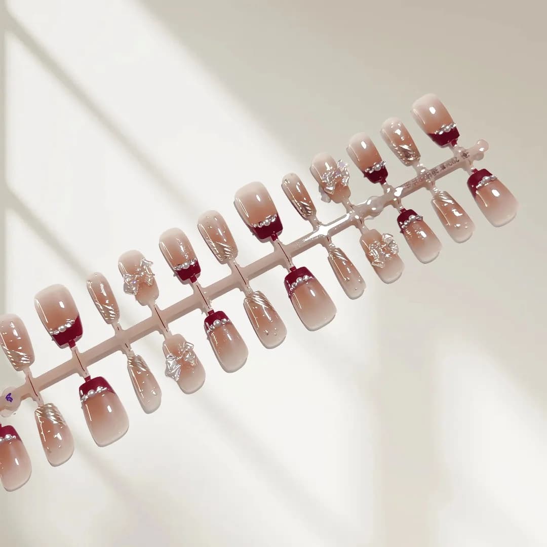 Faux ongles courts French manucure paillettes dorées et nœud